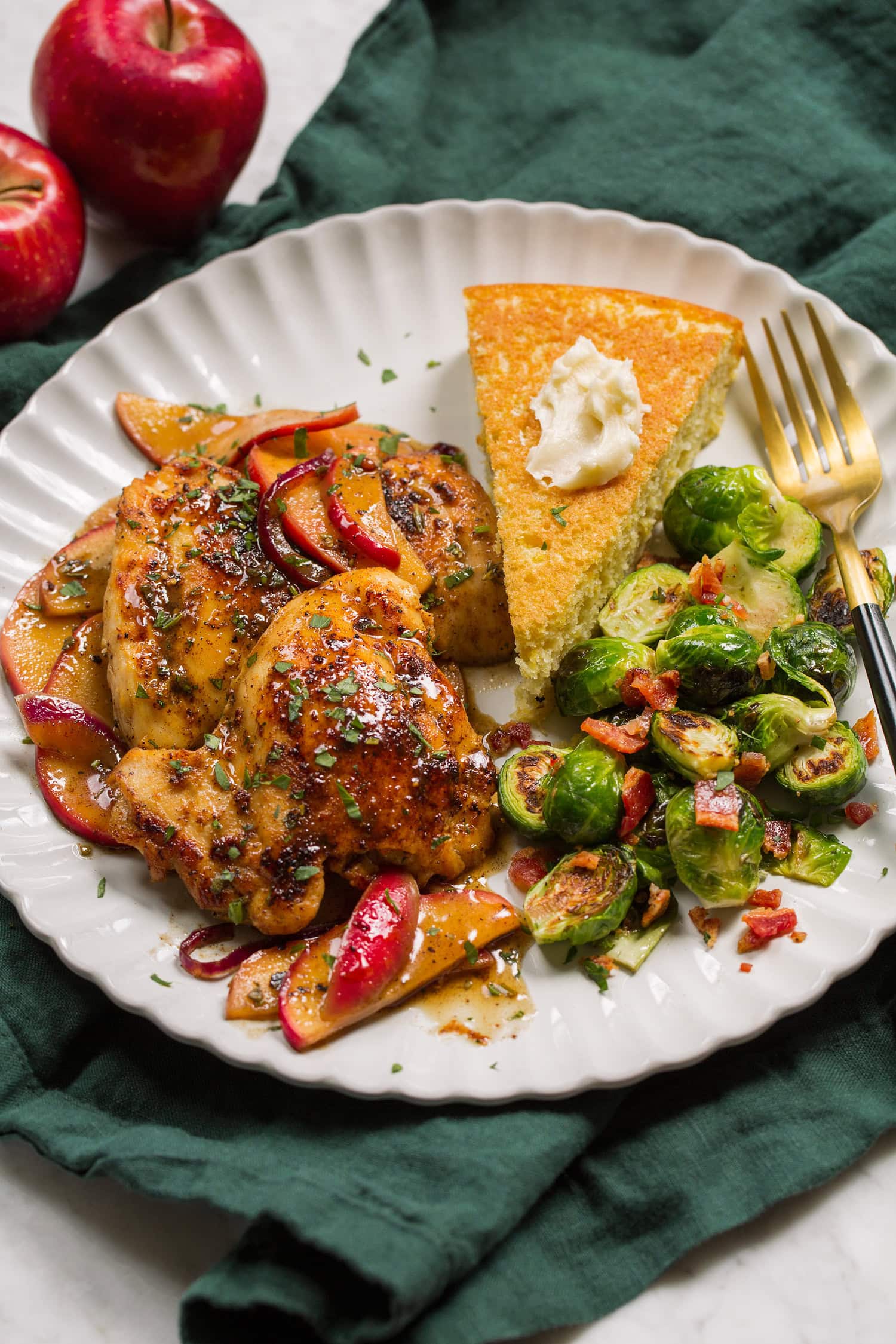 Chicken thighs and apples served with cornbread and brussels sprouts.