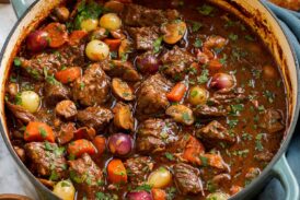 Beef bourguignon in a blue wide braiser pot.