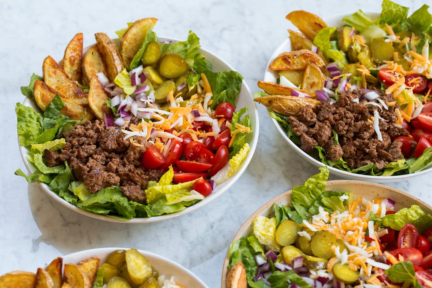 Four assembled burger bowls showing how to layer.