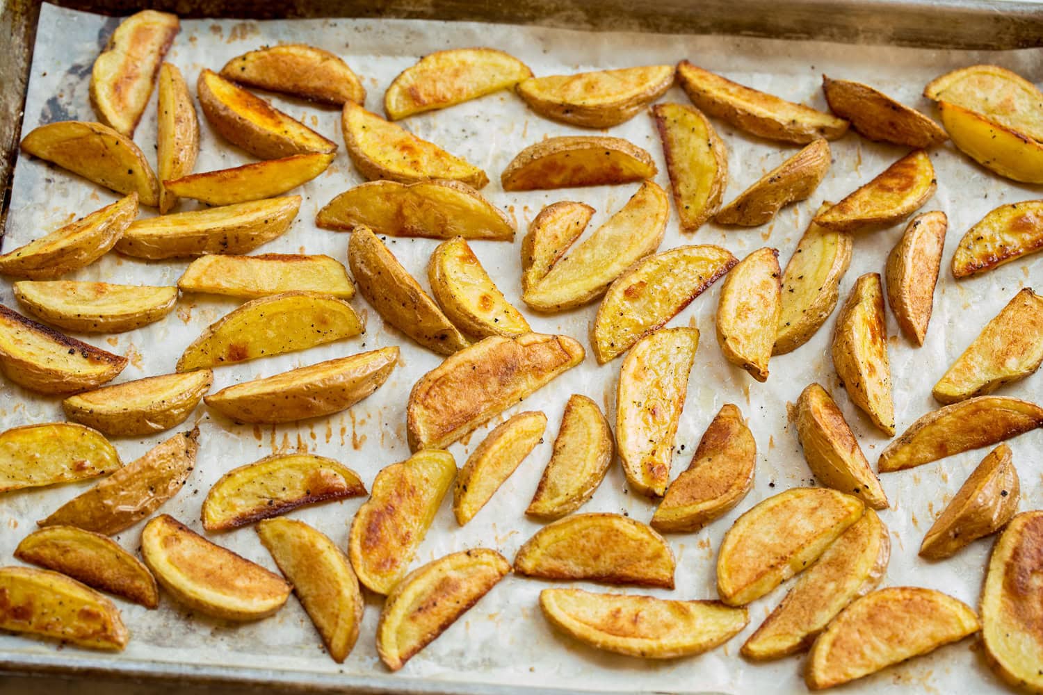 Oven fries shown after baking on baking sheet.
