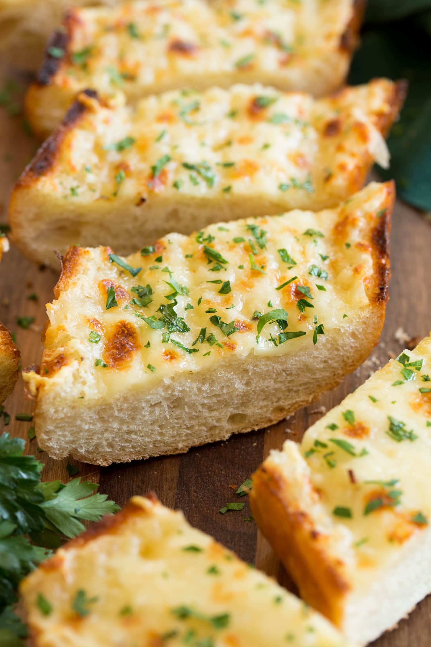 Close up photo of slice of garlic bread with cheese.