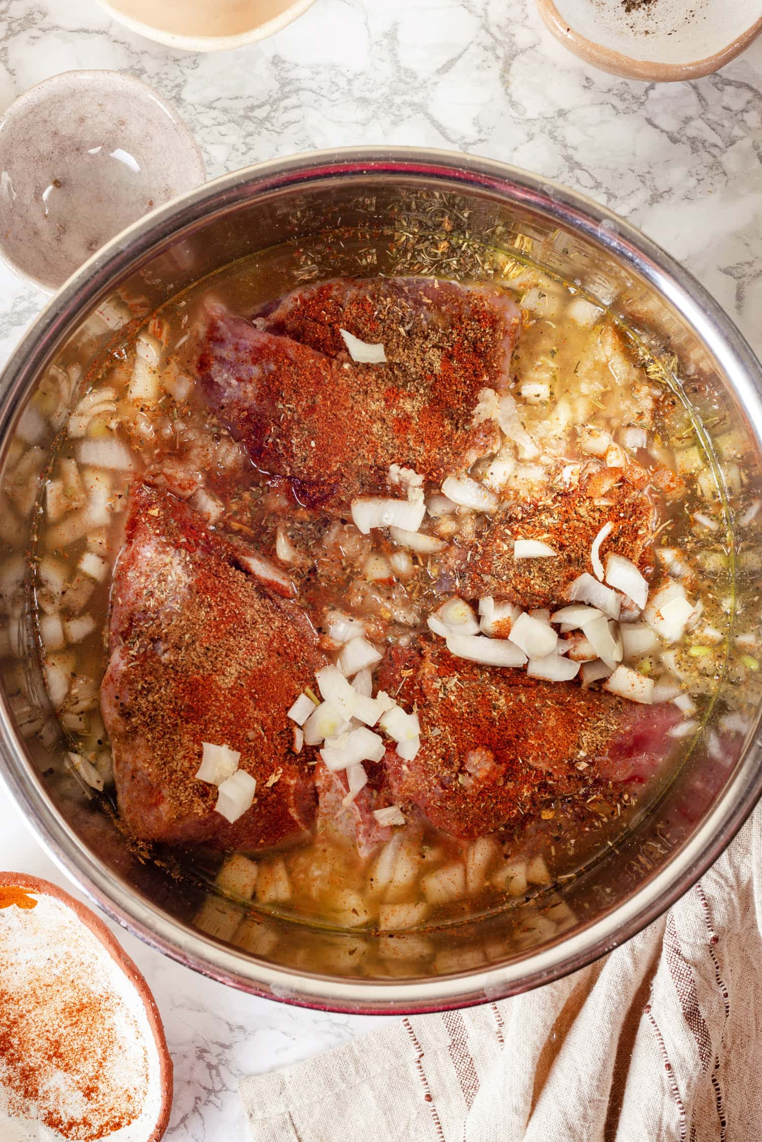 Pork chunks in broth covered in Mexican spices and onion.
