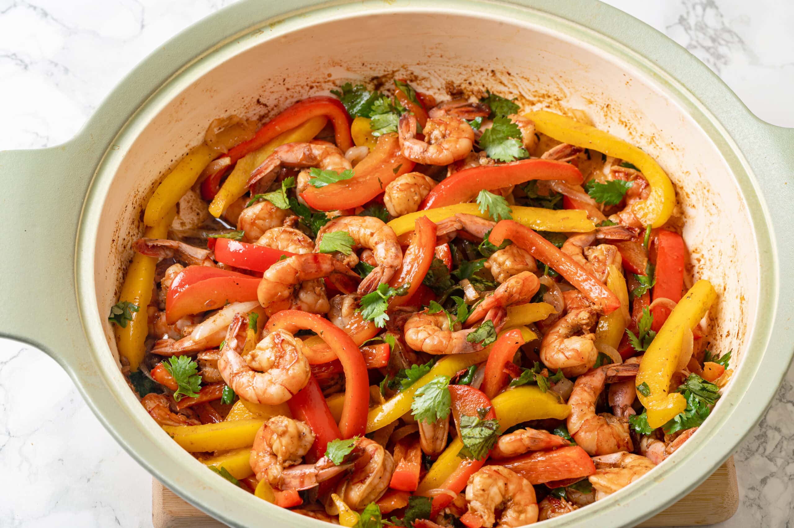 Sauteed shrimp and bell pepper mixture in a skillet.
