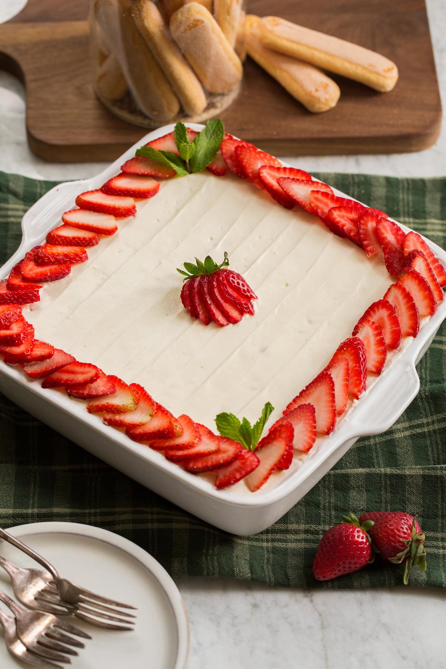 Strawberry Cheesecake Tiramisu shown as a whole square cake in baking dish.