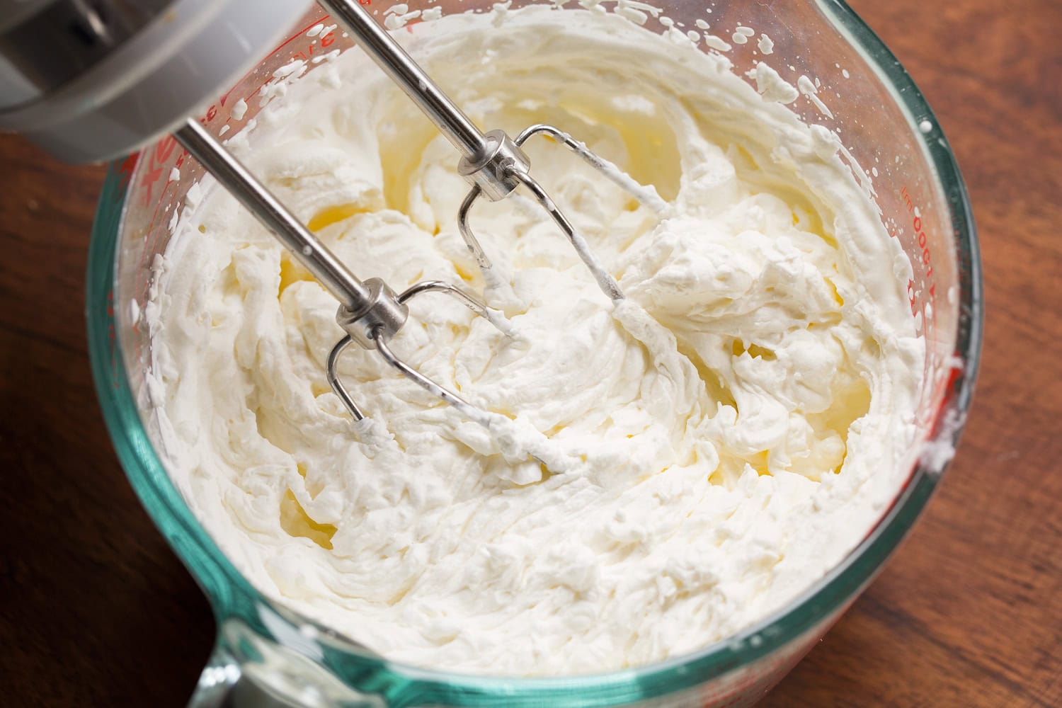 Whipped cream in a glass measuring cup.