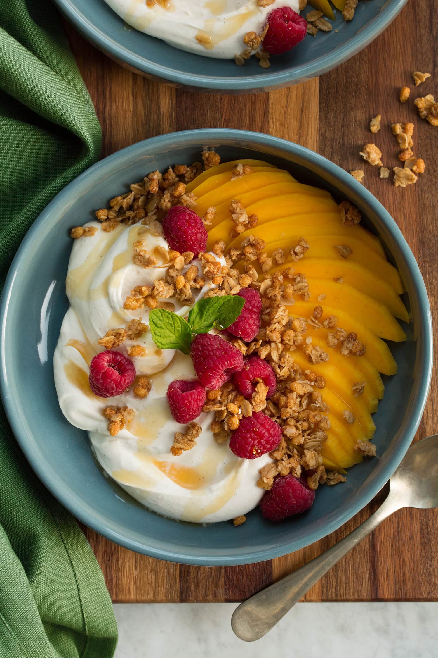 Whipped Greek Yogurt Whipped yogurt served with fruit and yogurt in a blue bowl over a wooden surface.